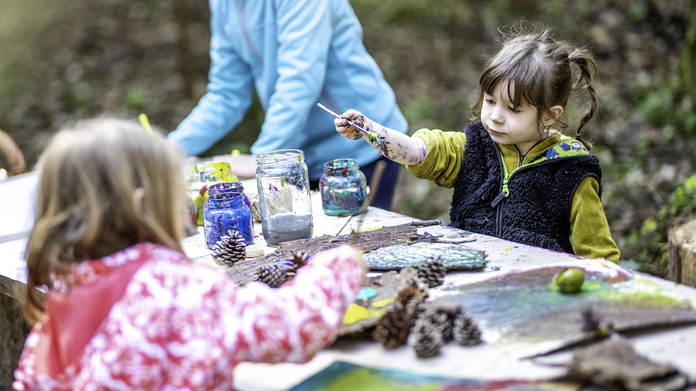 Marburg_Erzieher*in-werden_Waldkindergarten_iStock-1060115478 Kindergartenkinder beim Malen und Basteln im Freien. © iStock/vm