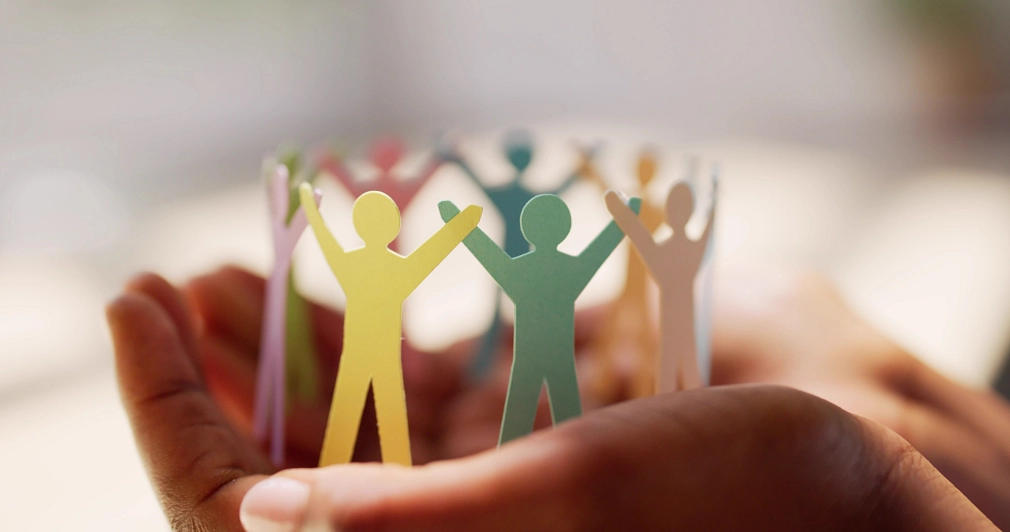 Marburg_Netzwerk-Engagement-Gruppe_iStock-1572436997 Abstrakte Figuren aus Papier stehen im Kreis und greifen die Hände. Vielfalt: Sie haben unterschiedliche Farben. © iStock/AndreyPopov