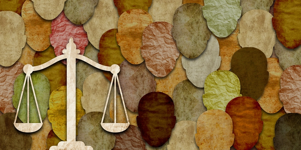 Marburg_Ombudspersonen Geflüchtete_iStock-1464817818 Grafik: Im Hintergrund abstrakte Gesichter und Köpfe in verschiedenen Farben. Im Vordergrund ist eine Waage zu sehen. © iStock/Saud Ansari
