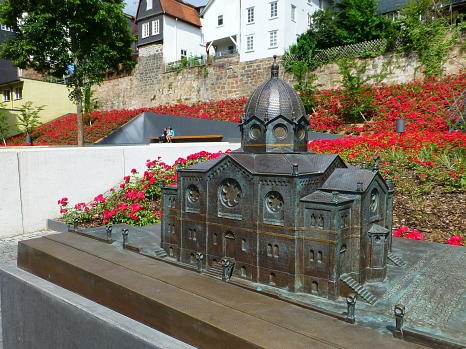 Bronzemodell der zerstörten Synagoge vor dem "Garten des Gedenkens" bei blühenden Rosen © Universitätsstadt Marburg