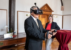 Oberbürgermeister Dr. Thomas Spies besichtigt die virtuelle alte Synagoge aus dem 14. Jahrhundert mit einer VR-Brille. © Patricia Grähling, Stadt Marburg