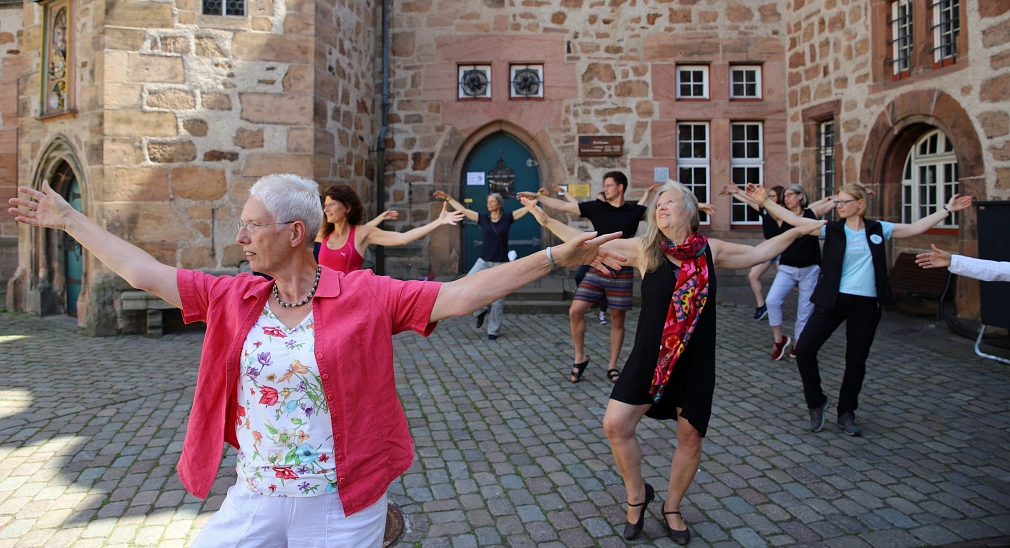 Auf dem Marburger Marktplatz vor dem Rathaus machen mehrere Menschen eine Qi Gong-Übung.&nbsp;&copy;&nbsp;Heike Döhn, i. A. d. Stadt Marburg
