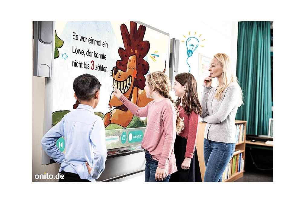 Drei Kinder und ihre Lehrerin stehen vor einem Whiteboard mit dem Bild eines lächelnden Löwen.&nbsp;&copy;&nbsp;Beltz&Gelberg; Martin Baltscheit