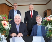 Der neue Ortsvorsteher Theodor Gölzhäuser und sein Vorgänger Lothar Böttner sitzen am Tisch. Oberbürgermeister Dr. Thomas Spies und Lothar Sprenger, Leiter des Fachdienstes Unterstützung kommunaler Gremien, stehen hinter den beiden.