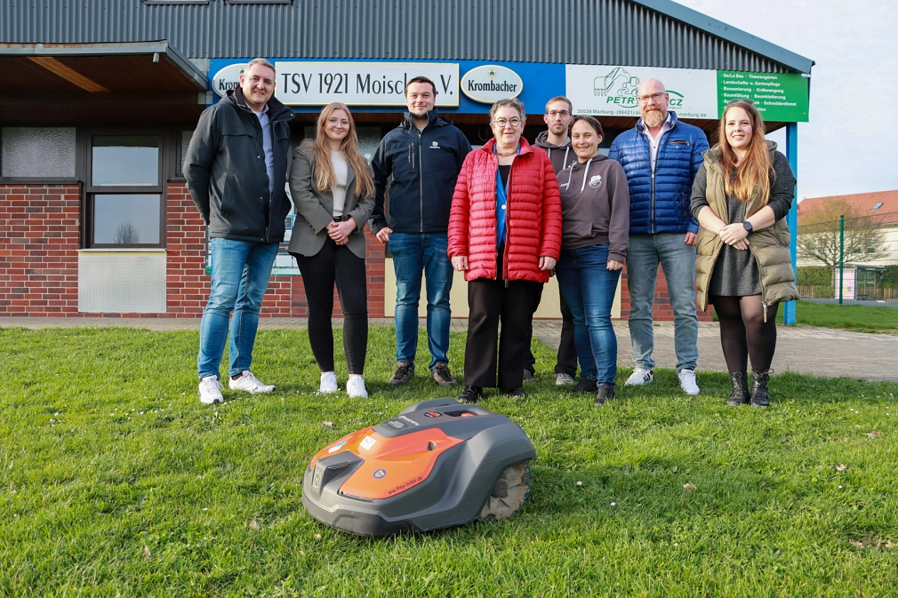 Der neue Rasenmähroboter zusammen mit den Verantwortlichen des TSV Moischt, der Firma Frey, Leiter des Fachdienst Sport und Frau Dinnebier&nbsp;&copy;&nbsp;Beatrix Achinger, i. A. d. Stadt Marburg