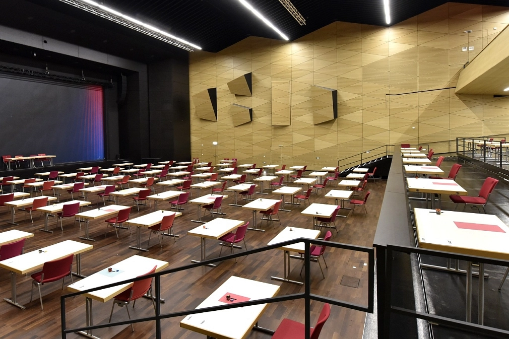 Saal-5 bestuhlt mit Doppeltischen einzeln gestellt.