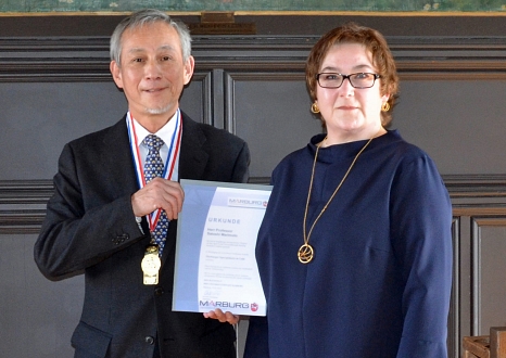 Professor Satoshi Morimoto war sehr gerührt von der Auszeichnung, die ihm Stadträtin Kirsten Dinnebier übergab. © Thomas Steinforth, Stadt Marburg
