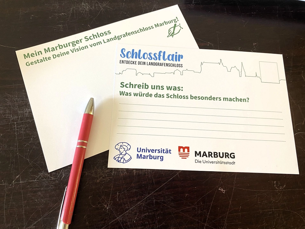 Zwei Postkarten liegen auf einem Tisch.