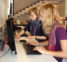 Zwei Schülerinnen recherchieren an den PC-Arbeitsplätzen im Medienbestand der Stadtbücherei.