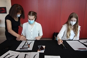 Künstlerin Nobuku Häufle-Yasuda (links) leitete Teilnehmer*innen beim Kalligrafie-Workshop an. (Foto: Heike Döhn, i.A. der Stadt Marburg)