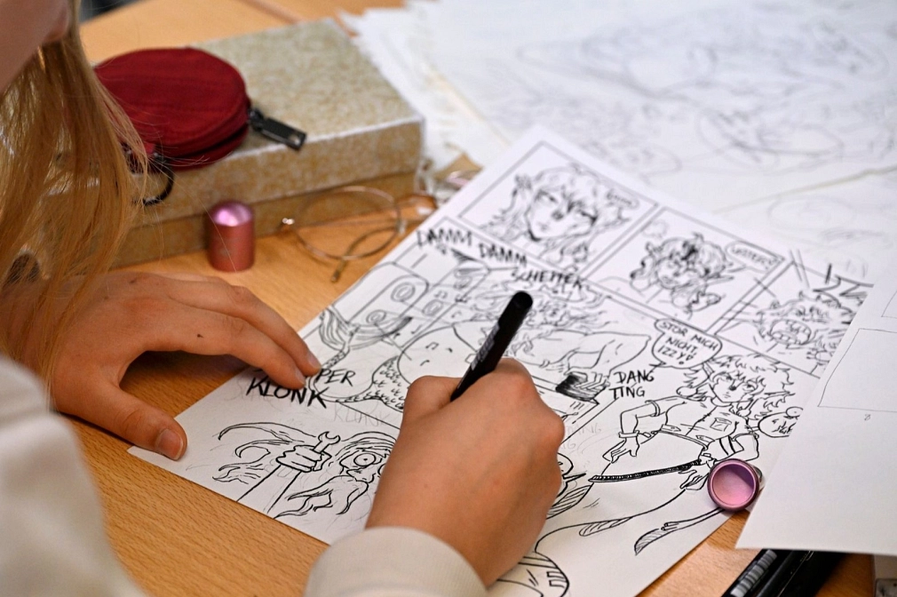 Sommerakademie: Kurs Wibke Brandes, Comic, Figuren, Geschichten Person zeichnet eine Comic, zu sehen sind Hände, Stift und Zeichnung