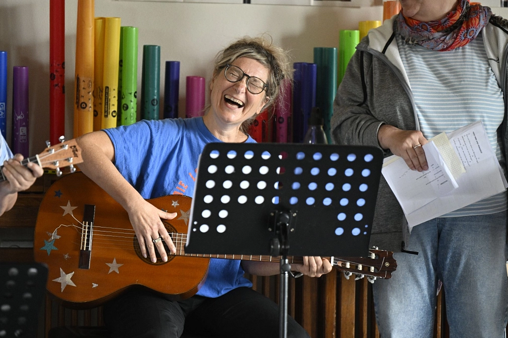 Fröhliche singende Person mit Gitarre.&nbsp;&copy;&nbsp;Georg Kronenberg