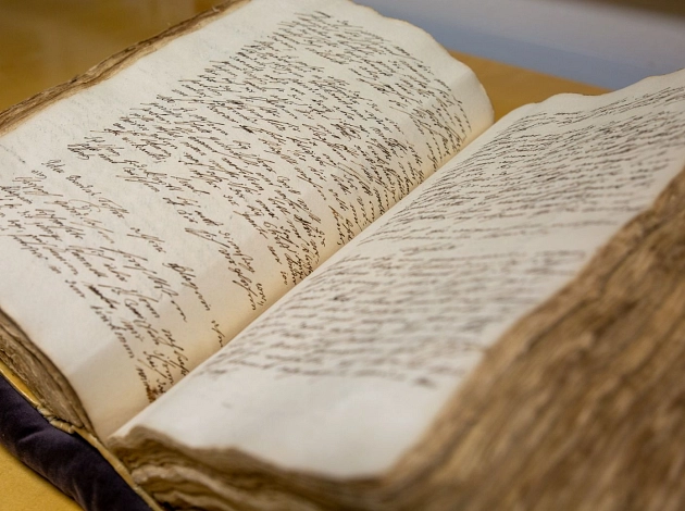 Zeugnis der Marburger Geschichte: Nahaufnahme vom Marburger Stadtbuch. Vergilbte Seiten, altertümliche Handschrift.