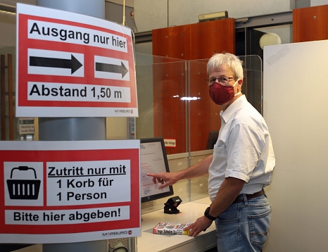 Stadtbüchereileiter Jürgen Holzer weist darauf hin, dass das Tragen eines Mund- und Nasenschutzes Pflicht ist. © Thomas Steinforth, Stadt Marburg