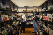 Stadträtin Kirsten Dinnebier und Stadtbücherei-Leiter Jürgen Hölzer zeigen eine Auswahl an beliebten Medien der Statdbücherei – neben Büchern sind das etwa auch CDs und DVDs.