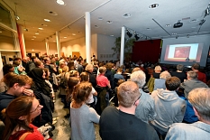 Auch im vollbesetzten Foyer hören noch Menschen dem Vortrag zu. © Georg Kronenberg