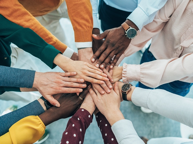 Arbeiten bei der Stadt Marburg ist Teamwork: Mehrere Menschen legen ihre Hände aufeinander. Zu sehen sind nur Unterarme und Hände, keine Gesichter.