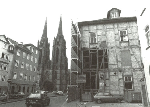 Historisches Foto vom Umbau der Stadtbücherei, die damals noch "Amerika-Haus" hieß, ab 1986: Freilegung der Außenwände und sichtbares Fachwerk. Im Hintergrund ist die Elisabethkirche zu sehen.&nbsp;&copy;&nbsp;Universitätsstadt Marburg