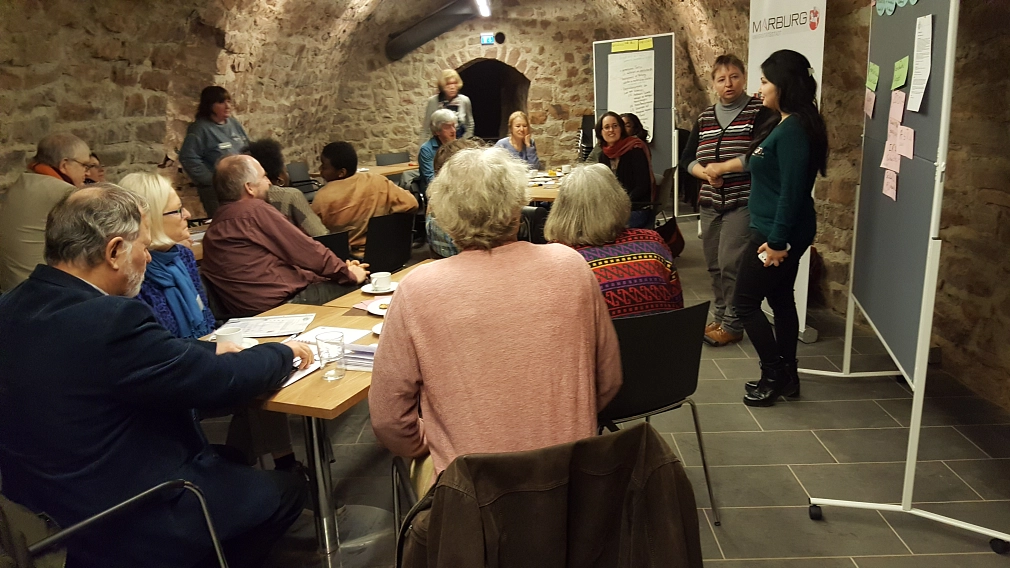 Personen sitzen an mehreren Tischen, sie unterhalten sich, arbeiten.&nbsp;&copy;&nbsp;WIR-Vielfaltszentrum, Stadt Marburg