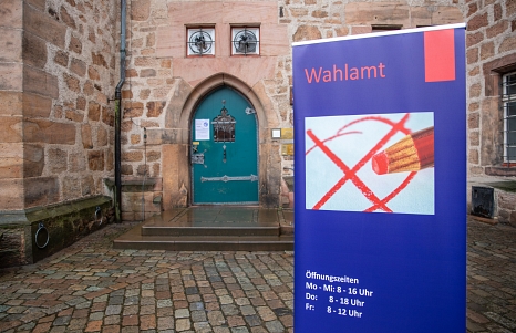 Abgebildet ist ein Aufsteller mit der Aufschrift Wahlamt vor dem Rathauseingang. © Patricia Grähling, Stadt Marburg