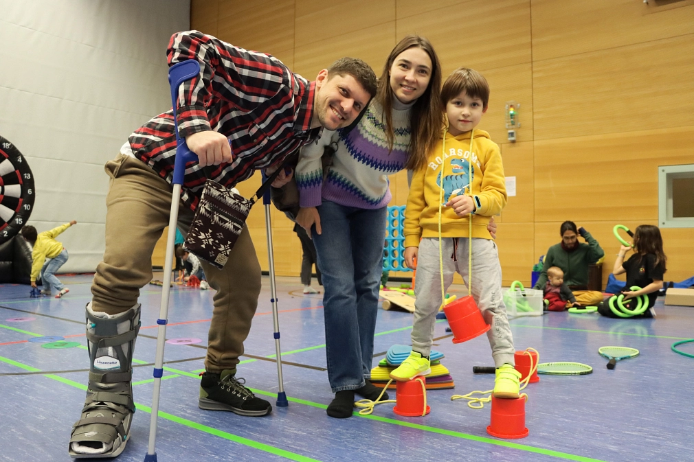 Ein Mann, eine Frau und ein Kind probieren sich beim Open Sunday am Balancieren auf Dosenstelzen aus.&nbsp;&copy;&nbsp;Beatrix Achinger, i.A.d. Stadt Marburg